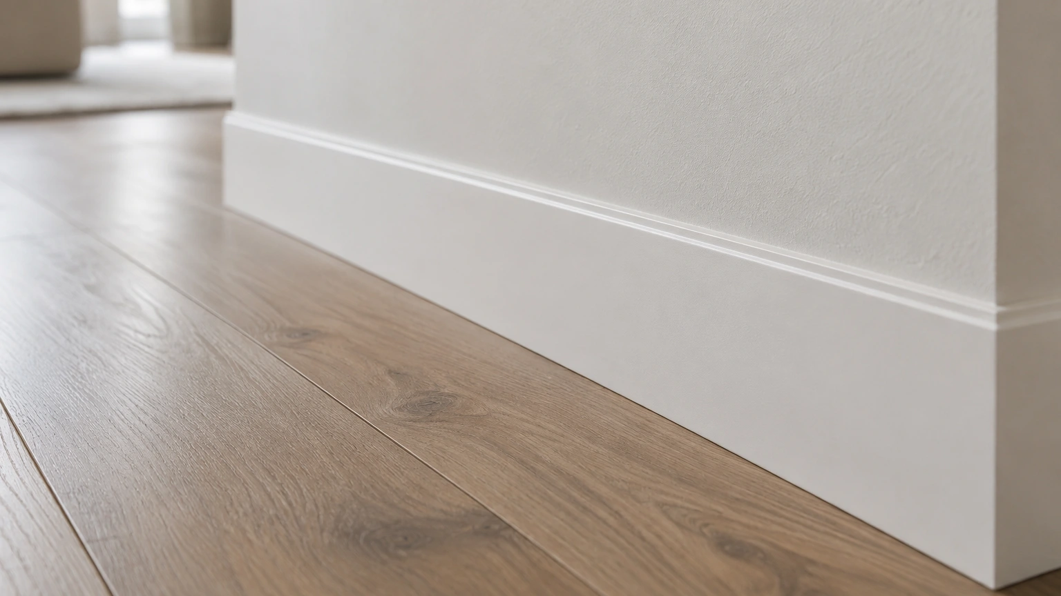 Close-up van een witte plint langs de overgang tussen vloer en wand